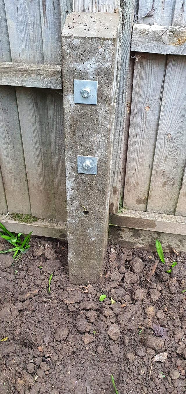 Concrete spur bolted to a leaning timber fence post, fitted by AWGS Fencing in Wokingham